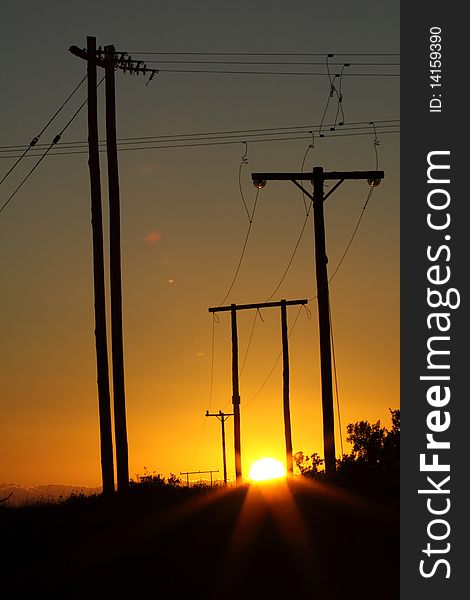 The sun setting behind a group of powerlines. The sun setting behind a group of powerlines