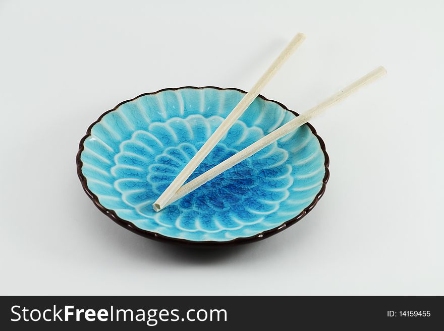 Far Eastern table setting with chopsticks on a blue plate. Far Eastern table setting with chopsticks on a blue plate.