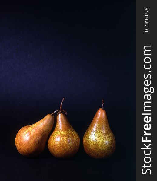 Three pears isolated on dark background