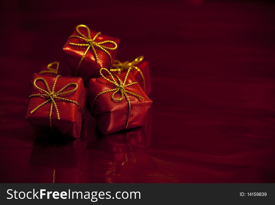 Close-up photograph of small red gift boxes on an abstract red background. Good for use with Valentines Day and Christmas themes. Close-up photograph of small red gift boxes on an abstract red background. Good for use with Valentines Day and Christmas themes