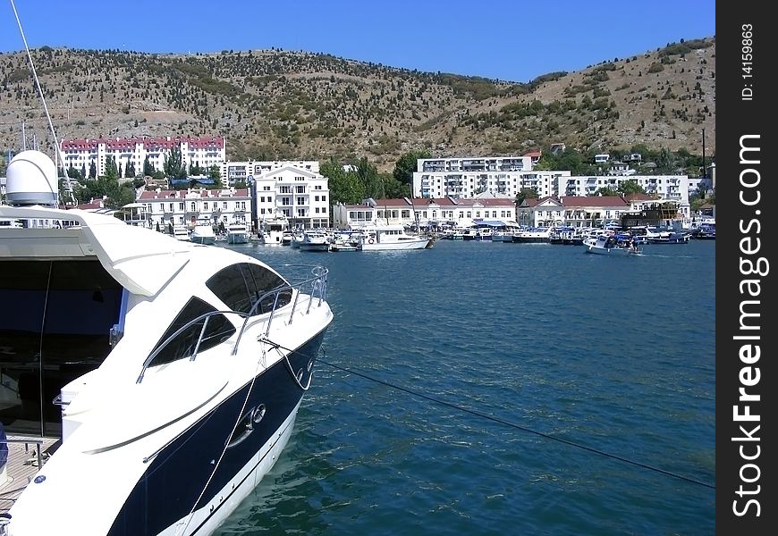 Yacht berthed in the bay against the backdrop of blue sea. Yacht berthed in the bay against the backdrop of blue sea