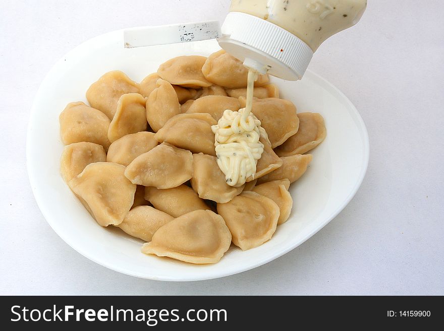 Ravioli in plate close-up on white background