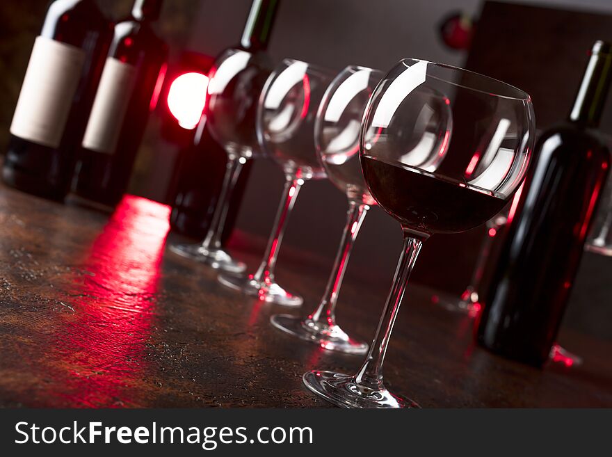 Glasses and bottles of red wine on a table in bar. Selective focus