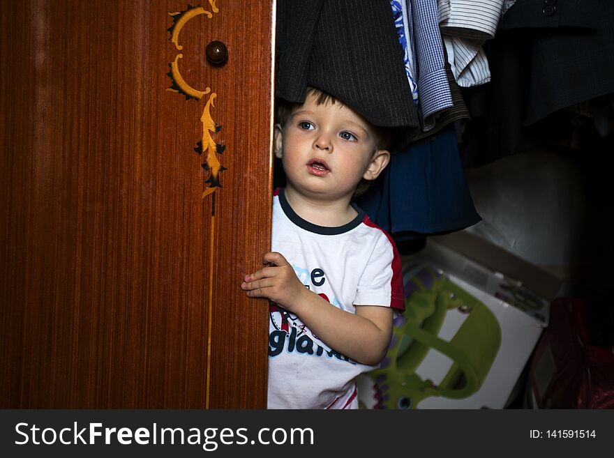 Little boy hiding inside wardrobe
