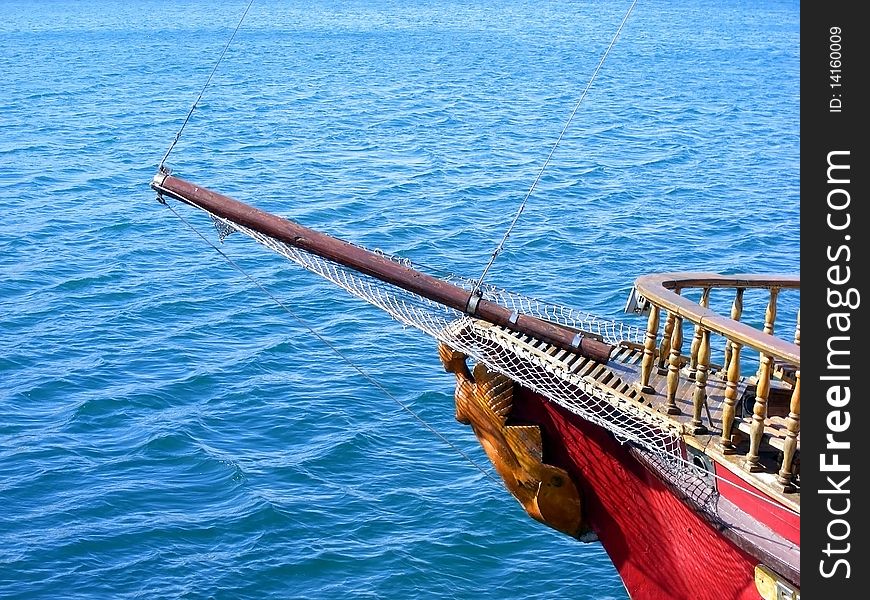 Nasal mast sailing ship with a carved wooden female figure against a background of blue sea. Nasal mast sailing ship with a carved wooden female figure against a background of blue sea