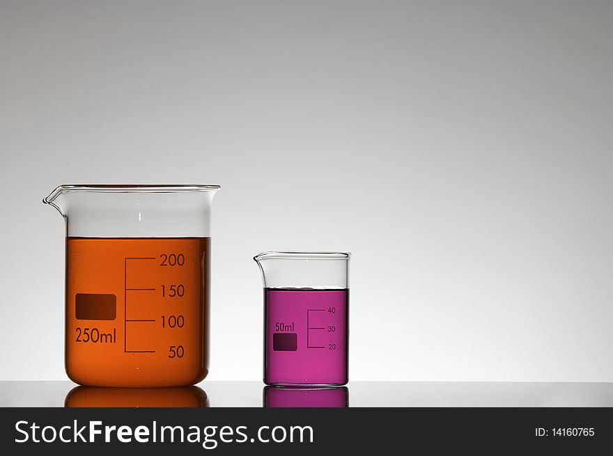 Two beakers with red and pink liquid