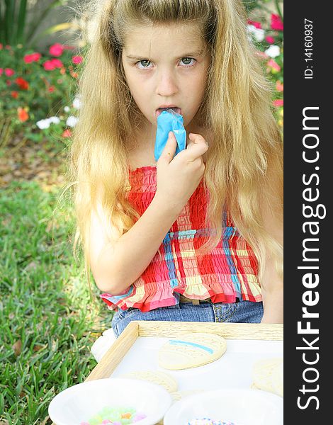 Shot of a child licking blue frosting