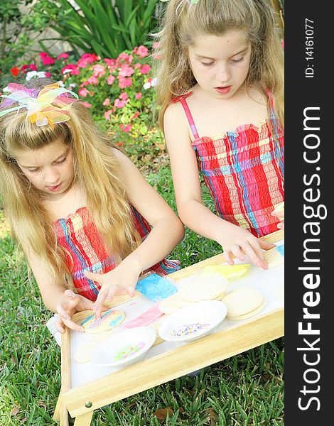 Little girls decorating cookies vertical