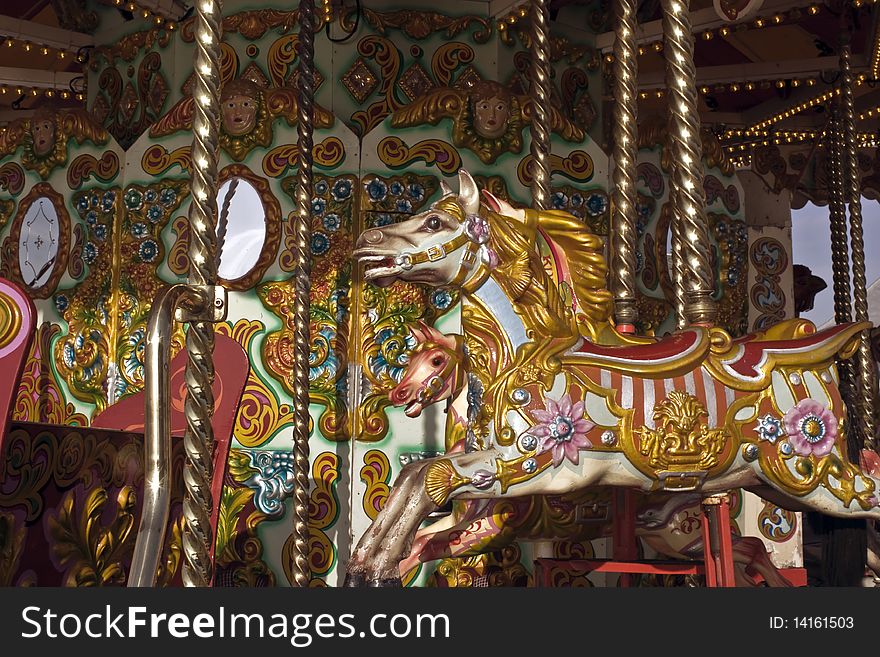 A brightly painted pony on a carousel on a sunny day. A brightly painted pony on a carousel on a sunny day