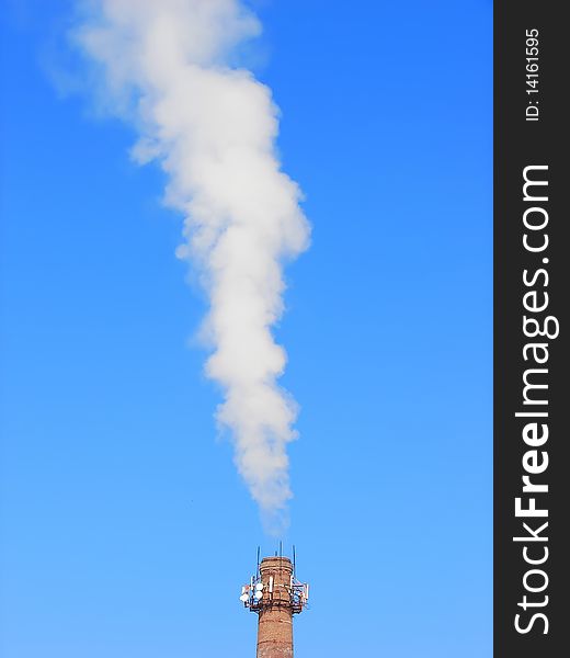 The smoke from the plant chimney on blue sky. The smoke from the plant chimney on blue sky