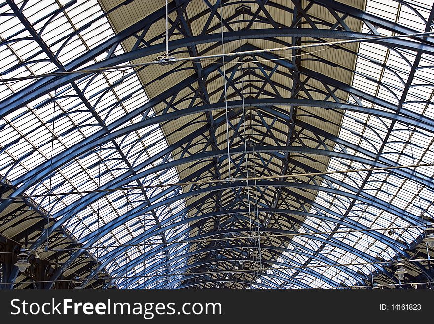 A glass and iron Victorian roof over a train station. A glass and iron Victorian roof over a train station