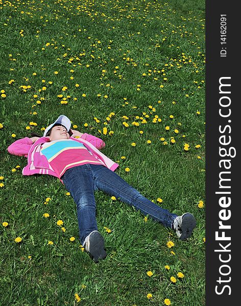 Resting child on green grass of meadow