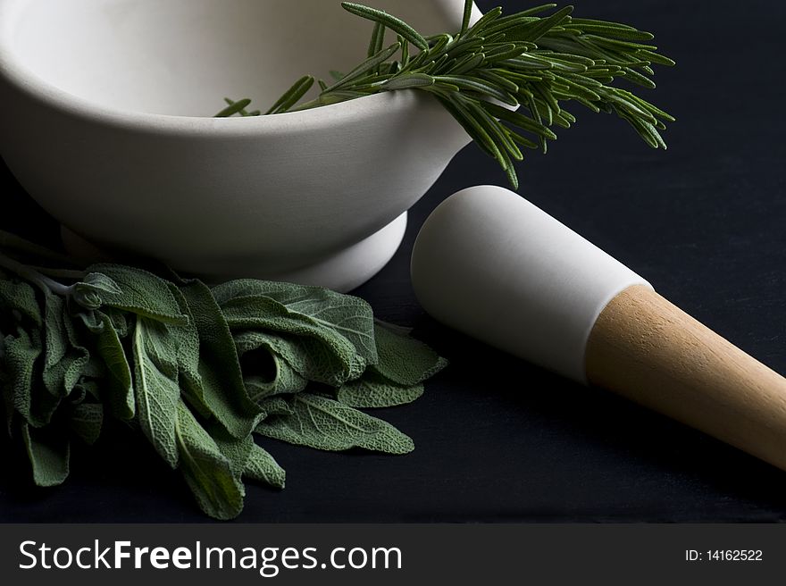 Mortar and Pestle With Fresh Herbs On A Slate Worktop