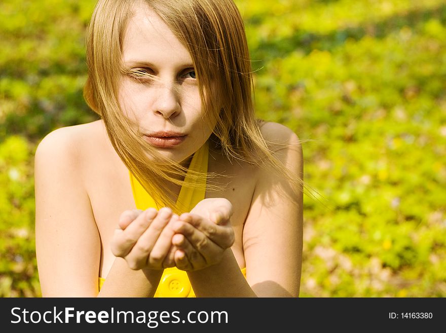 Attractive woman blowing kiss in spring nature. Copy space