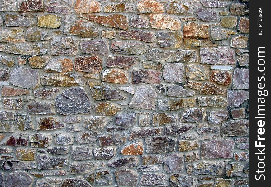 Multi colour stone wall pattern in sunny day, city Brixham UK. Multi colour stone wall pattern in sunny day, city Brixham UK