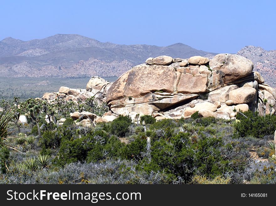 Desert view of Rock formation with mountain background. Desert view of Rock formation with mountain background