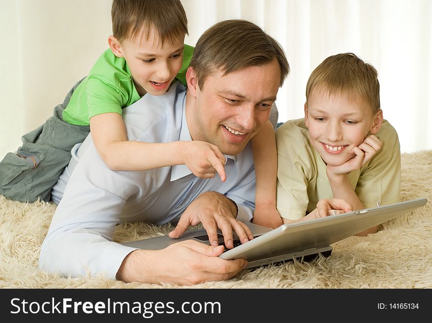 Two brothers and his father played on a laptop