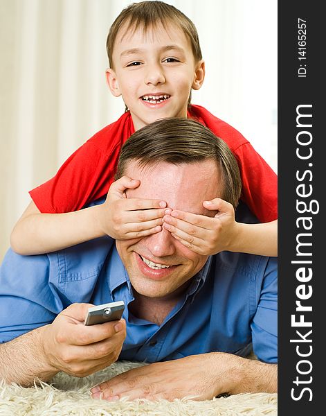 Son and father lying on the carpet