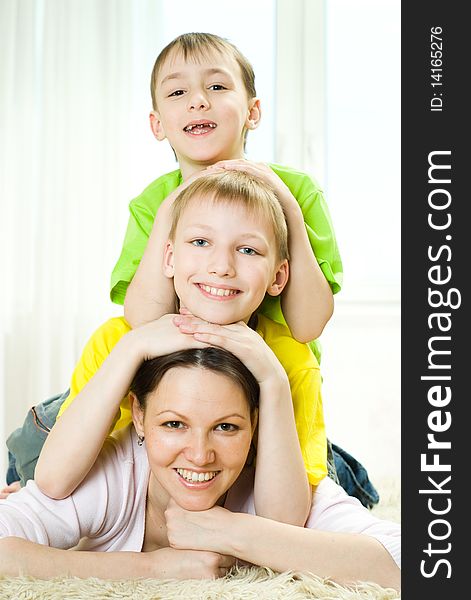 Young mother with her two children lying on the carpet. Young mother with her two children lying on the carpet