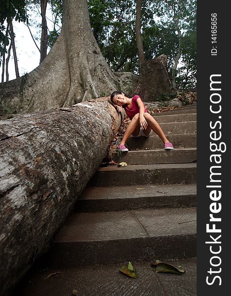 Young happy girl leaning on a dead tree. Young happy girl leaning on a dead tree