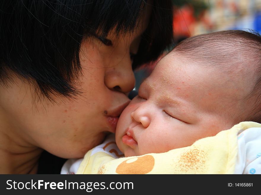 A chinese mother kissing her daughter. loving.