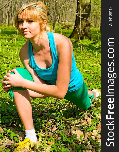 Pretty young woman doing exercises in the park