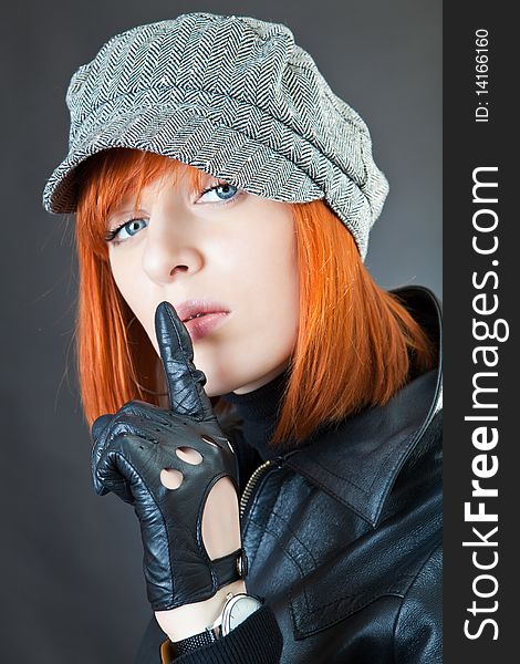 Girl in a suit of the biker against a dark background. Girl in a suit of the biker against a dark background