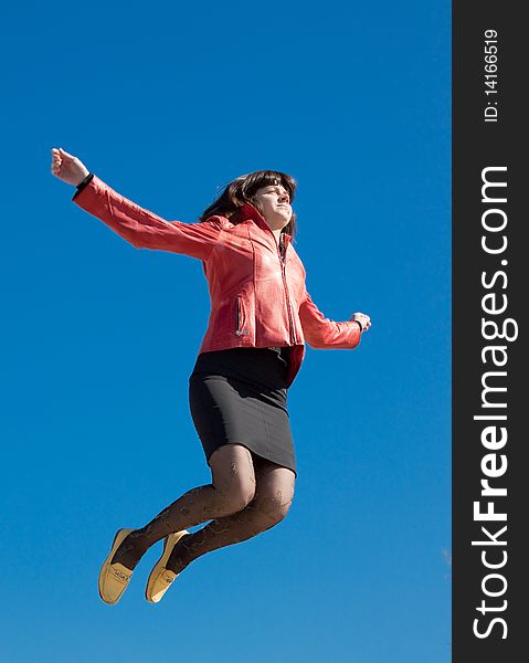 Jumping woman over blue sku