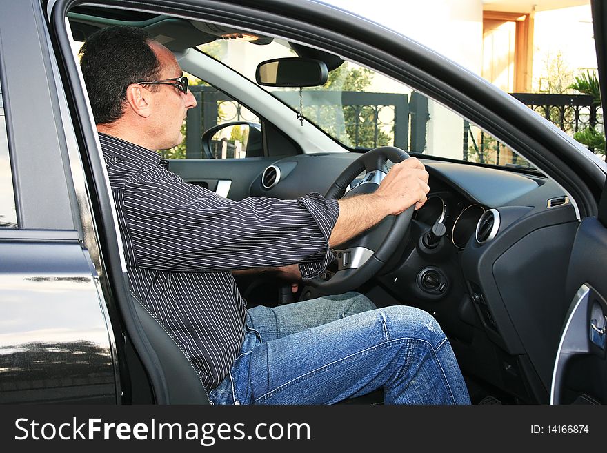 Man in new black car. Man in new black car.