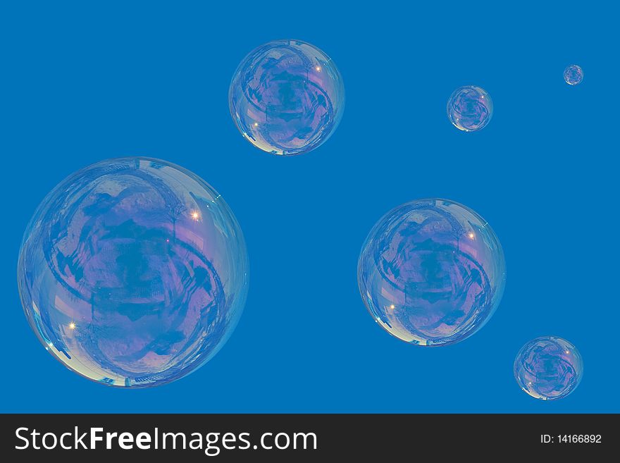 Many soap bubbles over a blue sky background