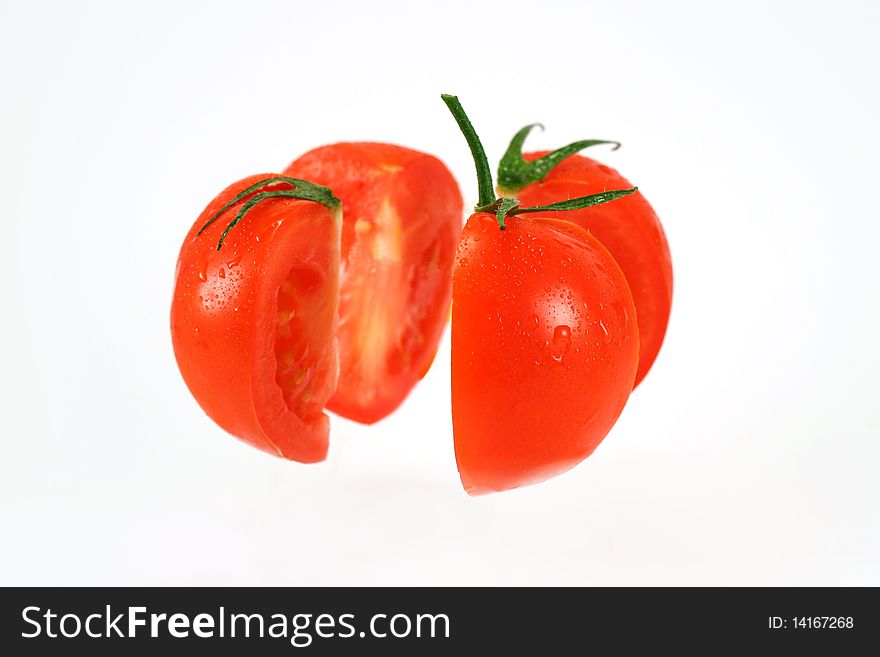 Fresh sliced tomato with water drops on white background.