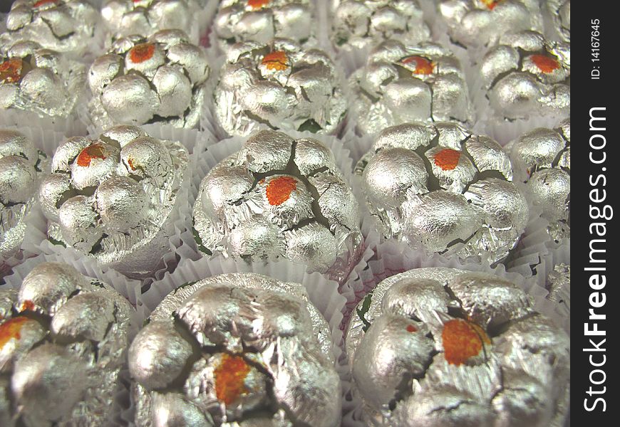 A flower shaped sweet made up of condensed milk and dry fruits ,decorated with silver foil. A flower shaped sweet made up of condensed milk and dry fruits ,decorated with silver foil.