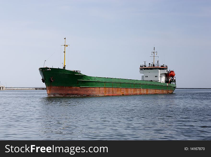 Cargo ship arriving to sea port