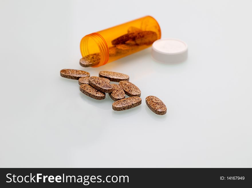 Some pills on a white background with a bottle. Some pills on a white background with a bottle.