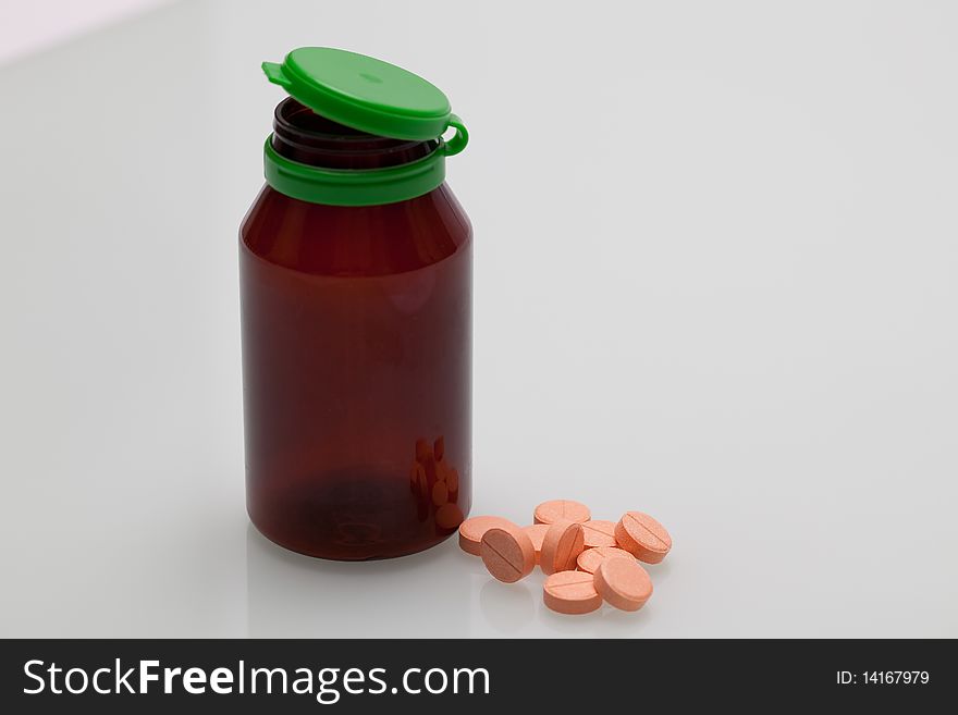 Some pills on a white background with a bottle. Some pills on a white background with a bottle.