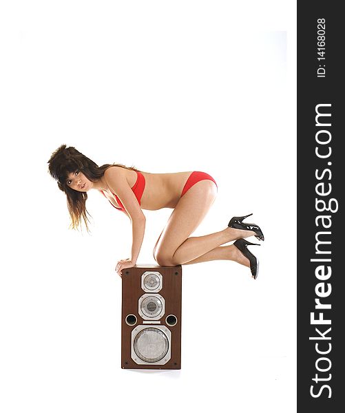 A young and female dj is hanging on a large speaker. Image isolated on a white background. A young and female dj is hanging on a large speaker. Image isolated on a white background.