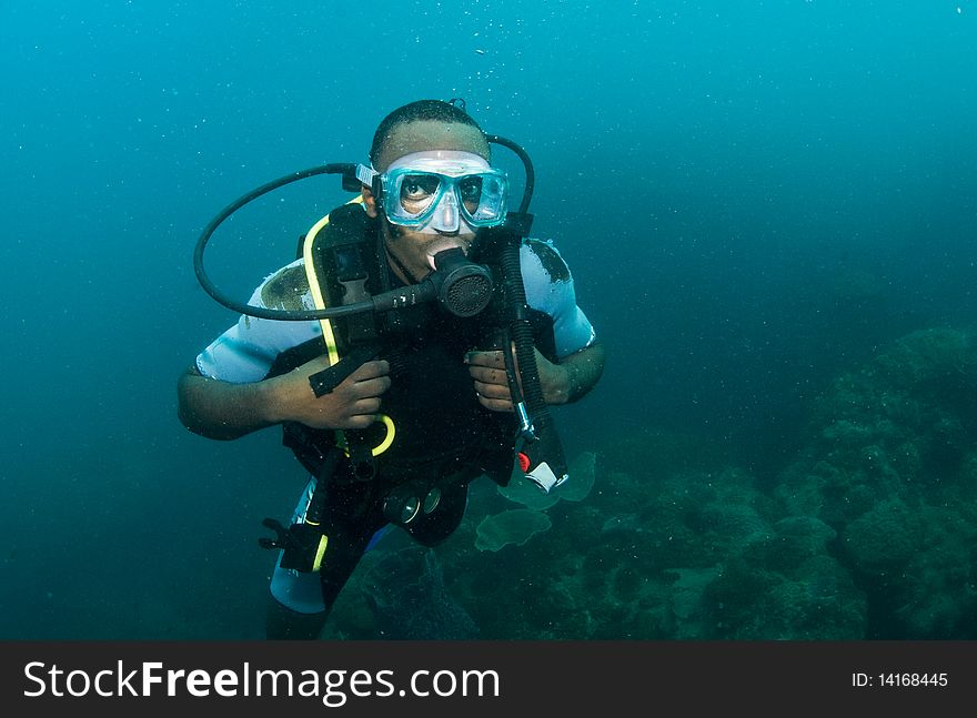 Scuba diver portrait swimming underwater. Scuba diver portrait swimming underwater