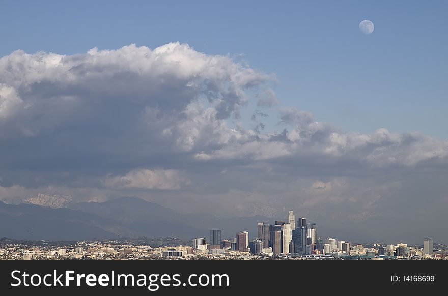 Stormy clouds hoovering over downtown Los Angeles on a late winter afternoon,with a wolfmoon in the sky,and snow covering the san bernardino mountains in the background. Stormy clouds hoovering over downtown Los Angeles on a late winter afternoon,with a wolfmoon in the sky,and snow covering the san bernardino mountains in the background.
