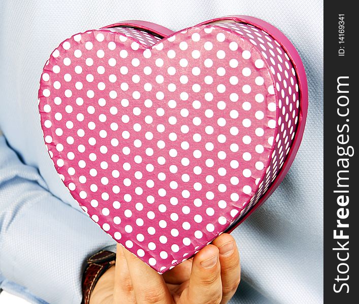 Businessman hiding a heart gift. Businessman hiding a heart gift