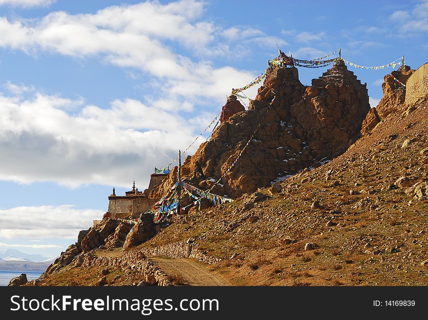 A tibetan castle on mountain with blue sky and cloud.