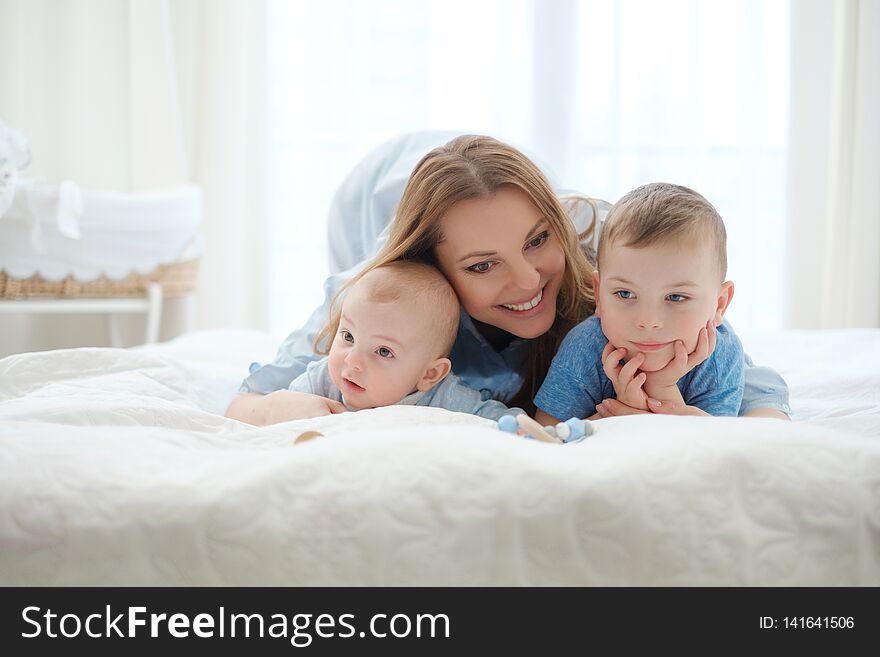 Happy Middle Aged Mother With Her Children In A Bed