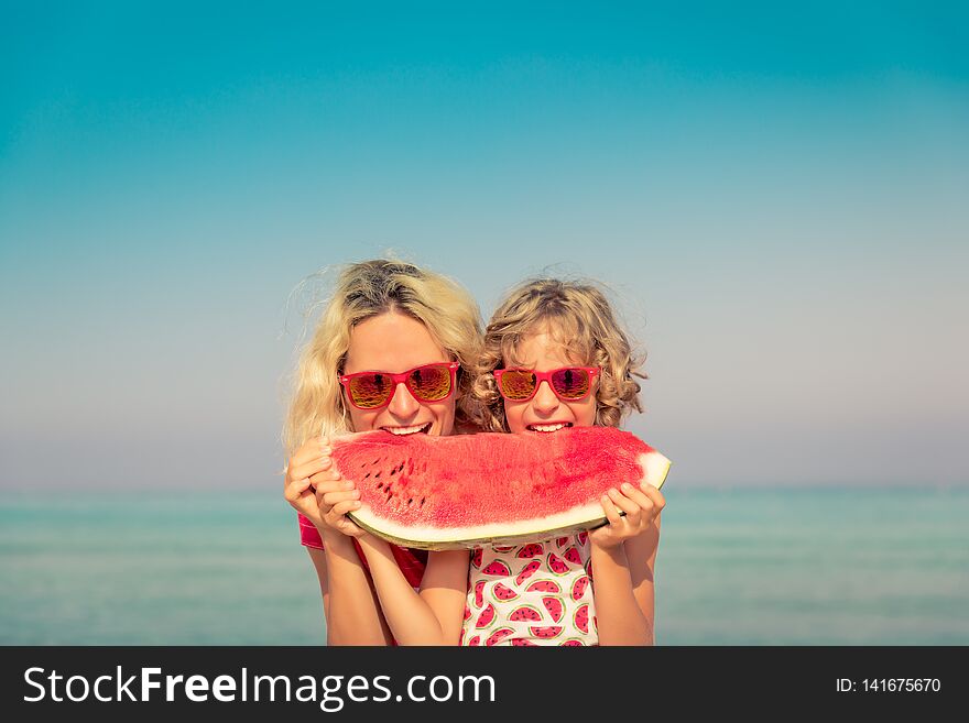 Happy family on summer vacation. People eating watermelon on the beach. Healthy lifestyle concept. Happy family on summer vacation. People eating watermelon on the beach. Healthy lifestyle concept