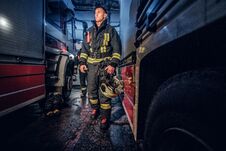 Full-length Portrait Of Two Brave Firemen In Protective Uniform Walking Between Two Fire Engines In The Garage Of The Royalty Free Stock Image Full-length Portrait Of Two Brave Firemen In Protective Uniform Walking Between Two Fire Engines In The Garage Of The Royalty Free Stock Image