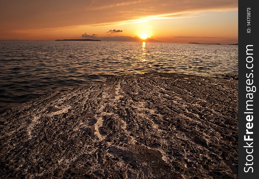 Sunset on the rocky beach with few distant islands on the horizon , Adriatic coast