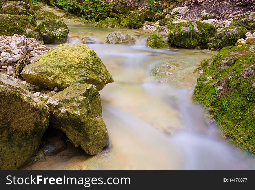 Water flows around stones in a long exposure. Water flows around stones in a long exposure.