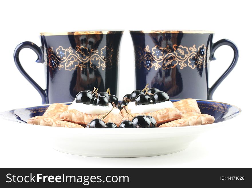 Dessert. Two cups of tea and cakes with black currant in sour cream. Isolated on white background. Dessert. Two cups of tea and cakes with black currant in sour cream. Isolated on white background