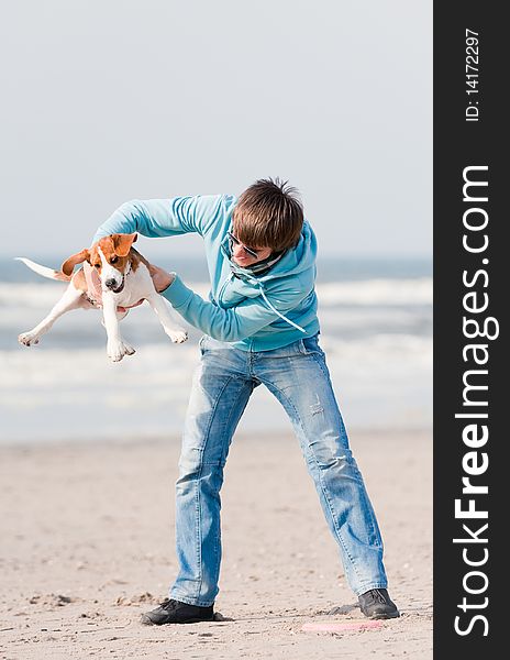 Young man playing with his beagle puppy. Young man playing with his beagle puppy