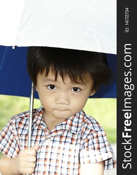 A young Asian boy holding an umbrella. A young Asian boy holding an umbrella