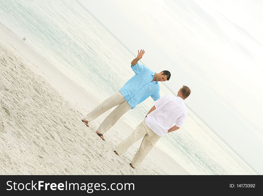 Shot of male models talking on the beach