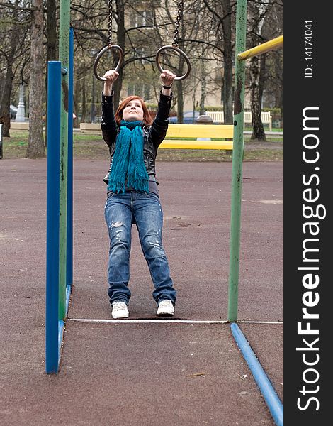 Sportive Girl Hanging On The Rings